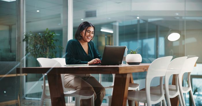 Young professional smiling and working at a desk